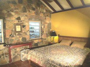 St John cottage Cactus Flower bedroom has stone walls, high ceiling and king sized bed and even a stone shower