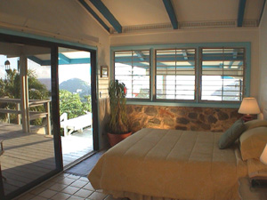 St John USVI vacation rental master bedroom with king sized bed and sliding glass doors that open onto the pool deck